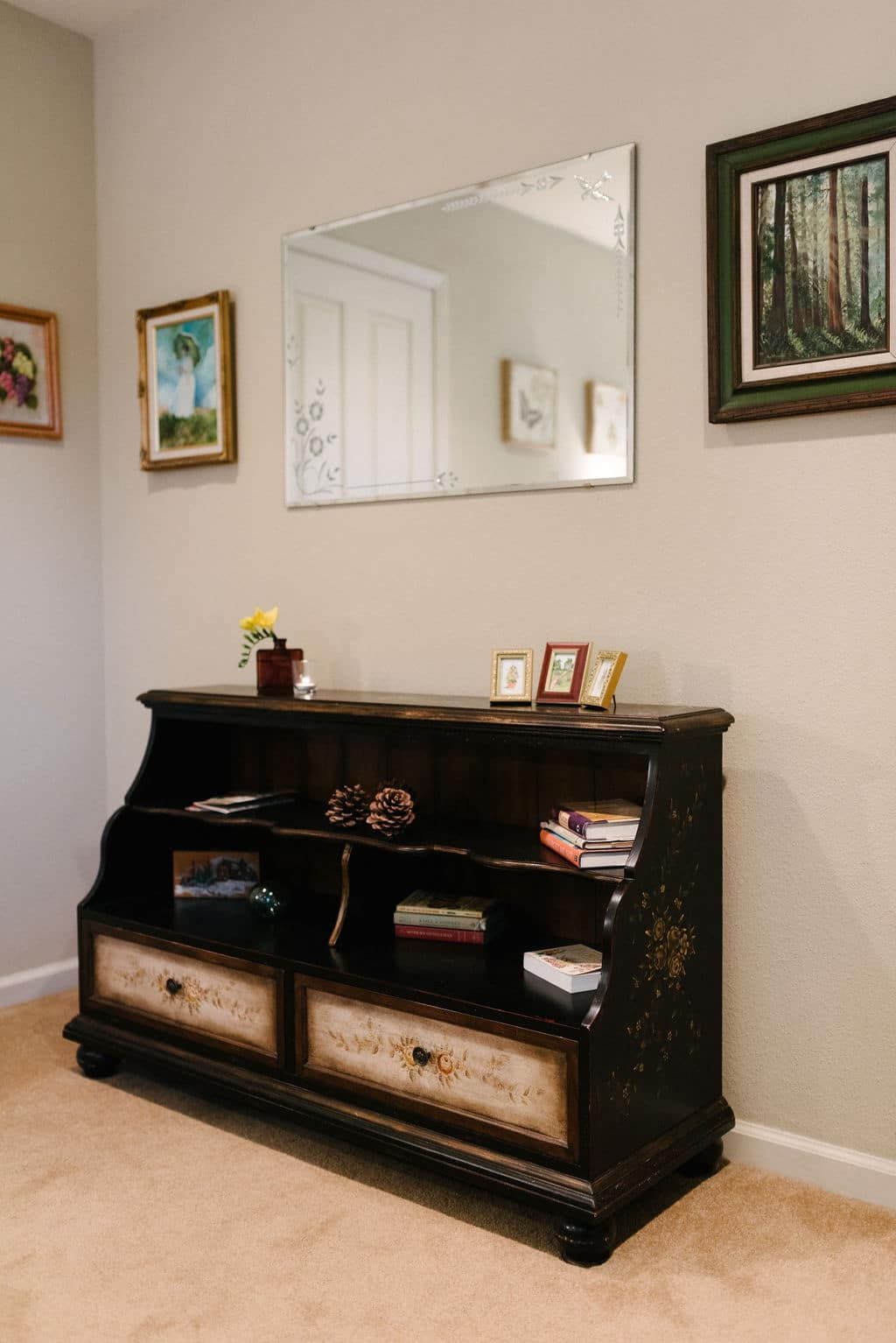 A room with a dresser and a mirror on the wall.