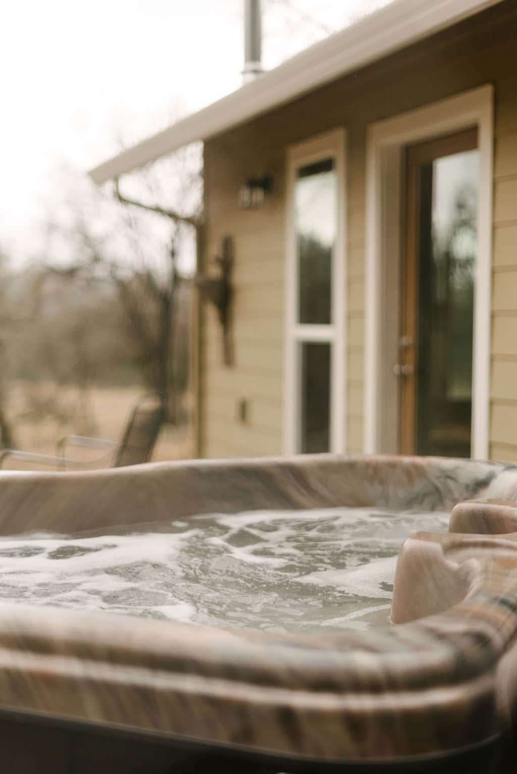 A hot tub is sitting in front of a house.