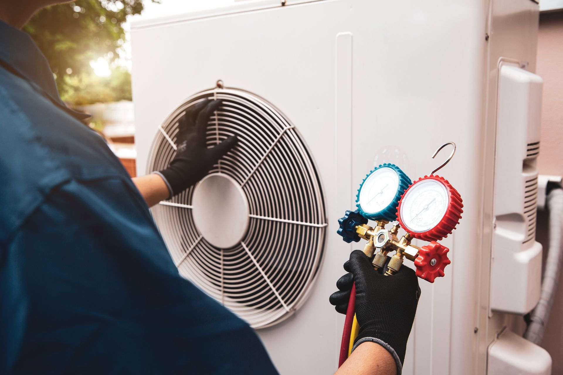 Technician inspecting outdoor air conditioner unit with tools and pressure gauges attached