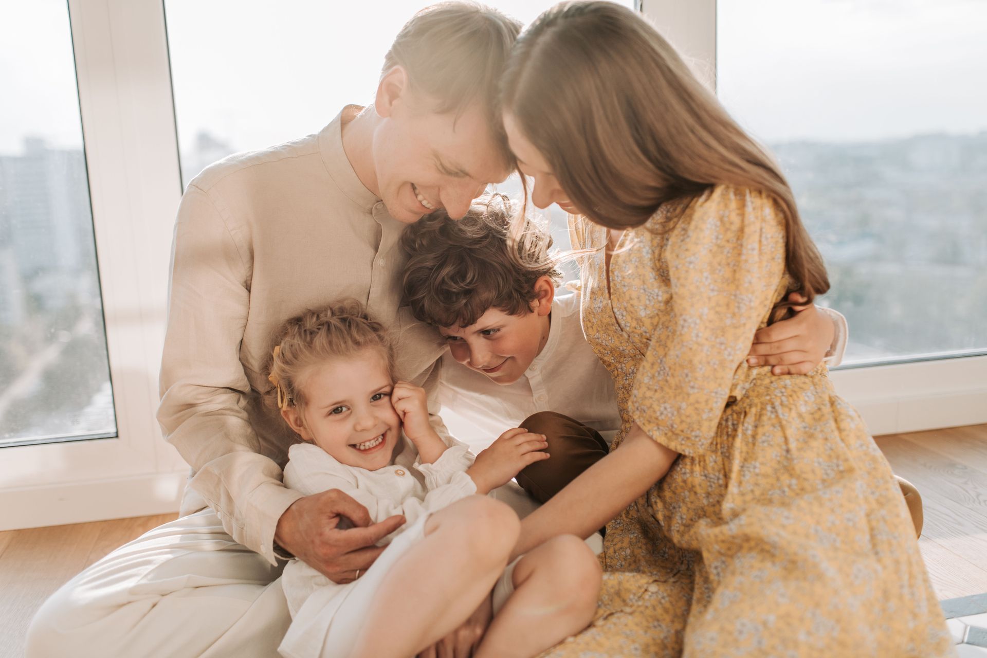 A family and a therapist give each other a high-five in a bright room.
