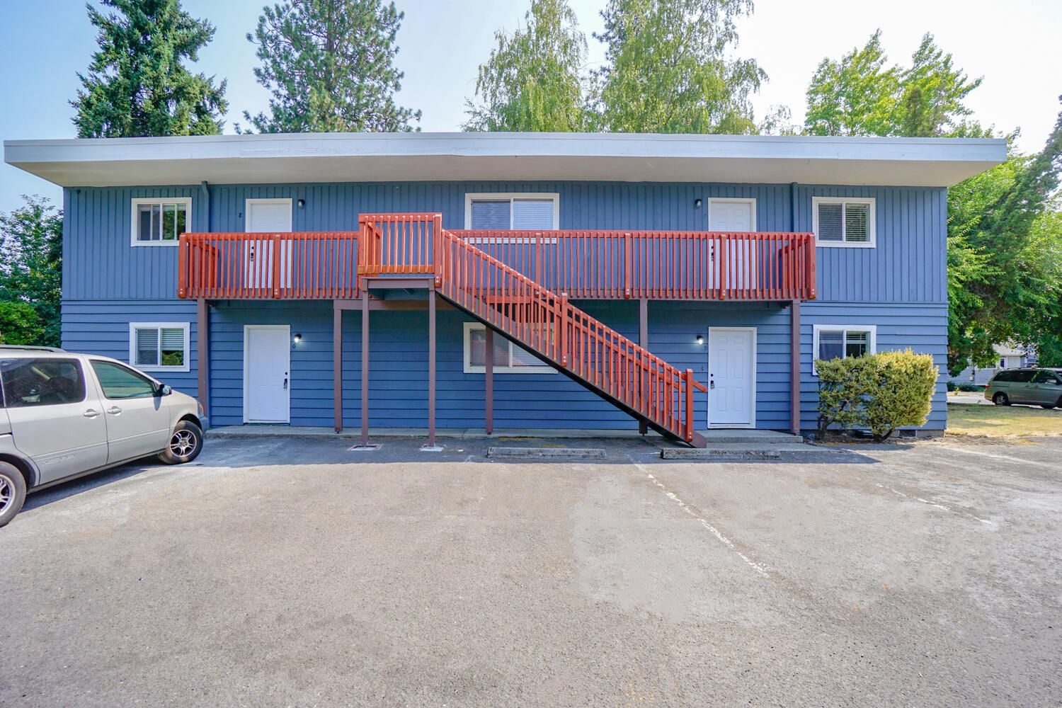 A blue apartment building with stairs leading up to the second floor