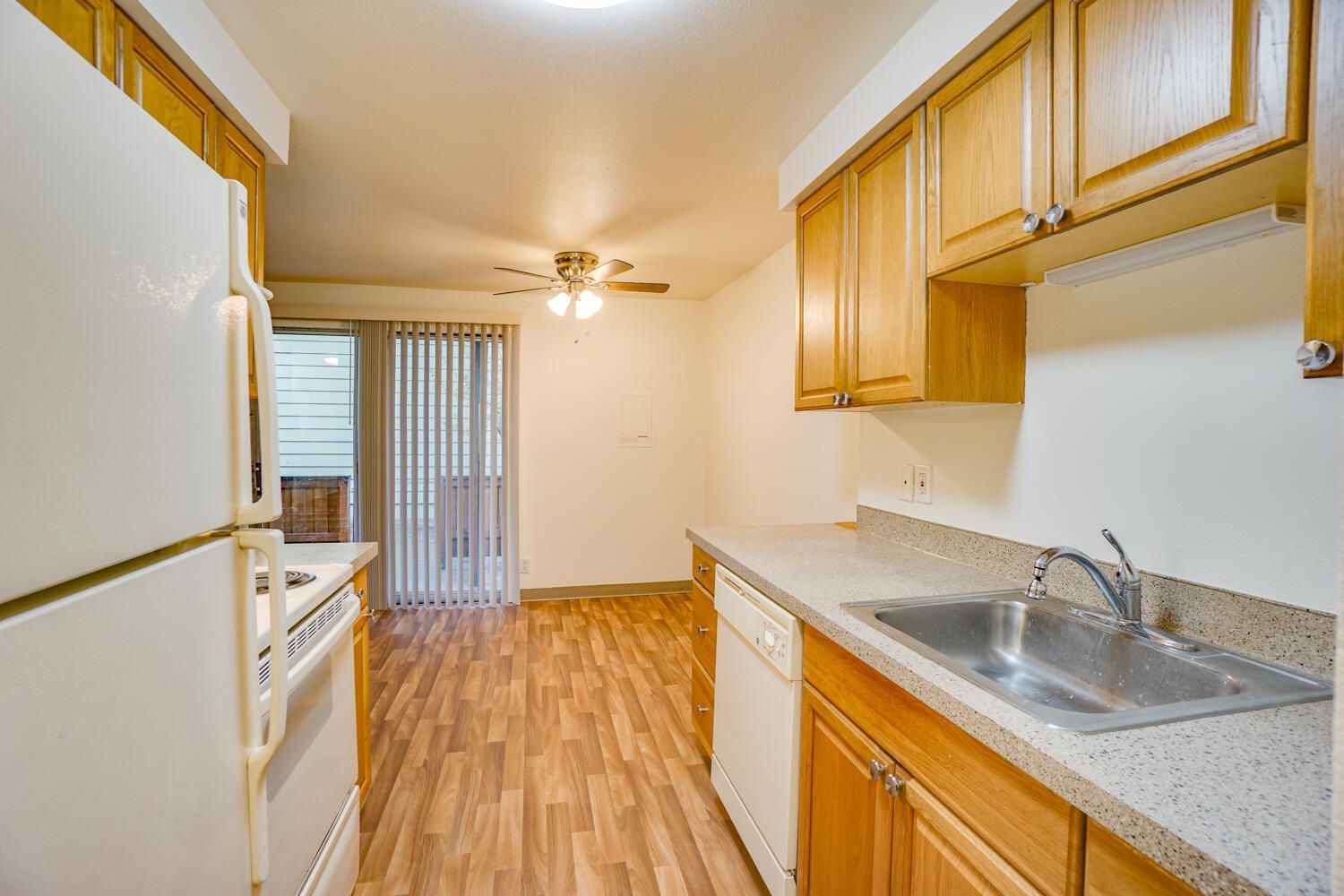 A kitchen with a refrigerator , sink , stove and dishwasher.