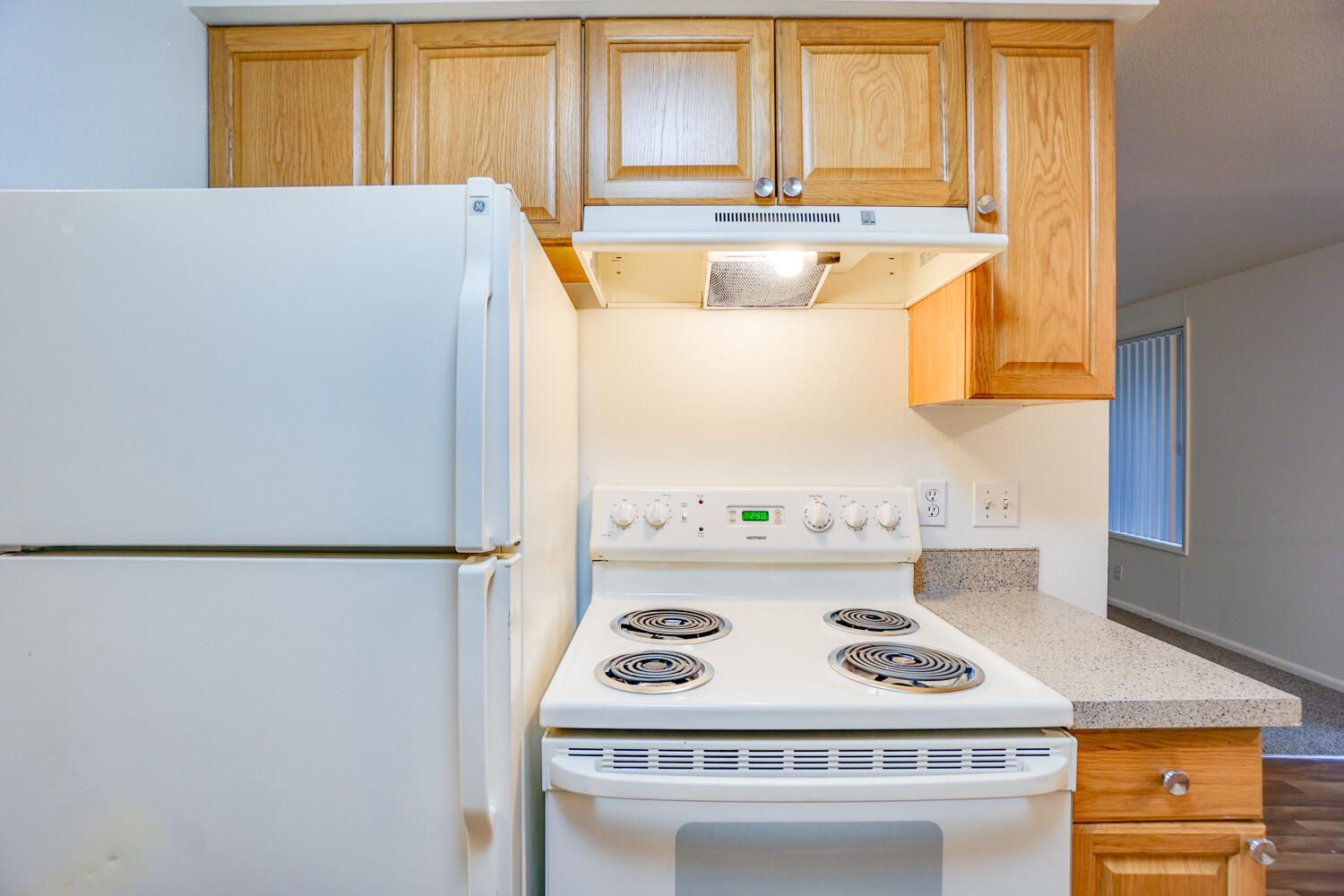 A kitchen with a stove , refrigerator , and cabinets.