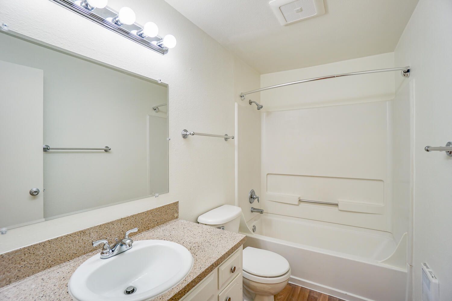 A bathroom with a sink , toilet , bathtub and mirror.
