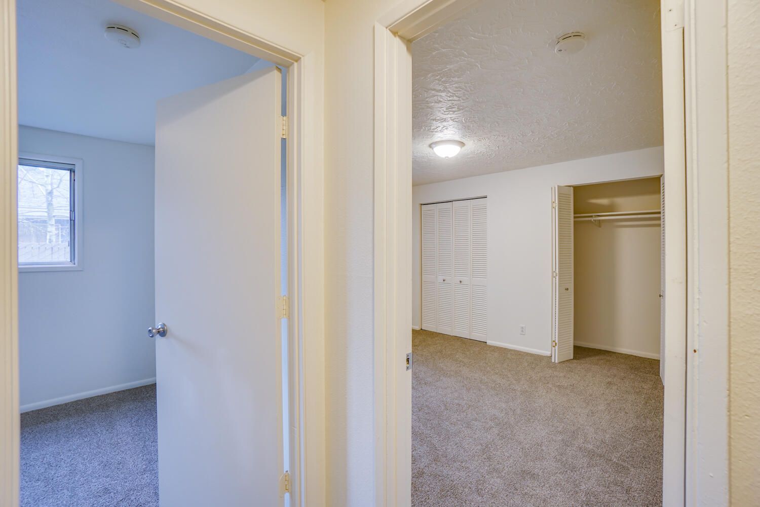A hallway leading to a bedroom and a closet in a house.