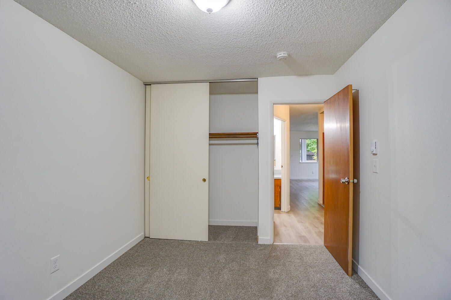 An empty bedroom with a closet and a door.
