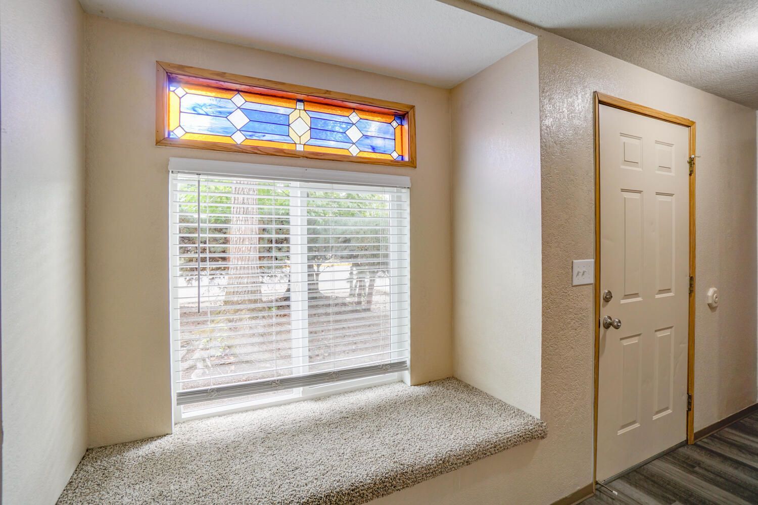A hallway with a window and a stained glass window.