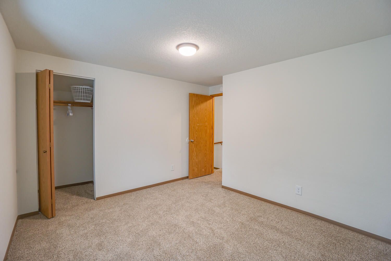 An empty bedroom with a closet and a light on the ceiling.
