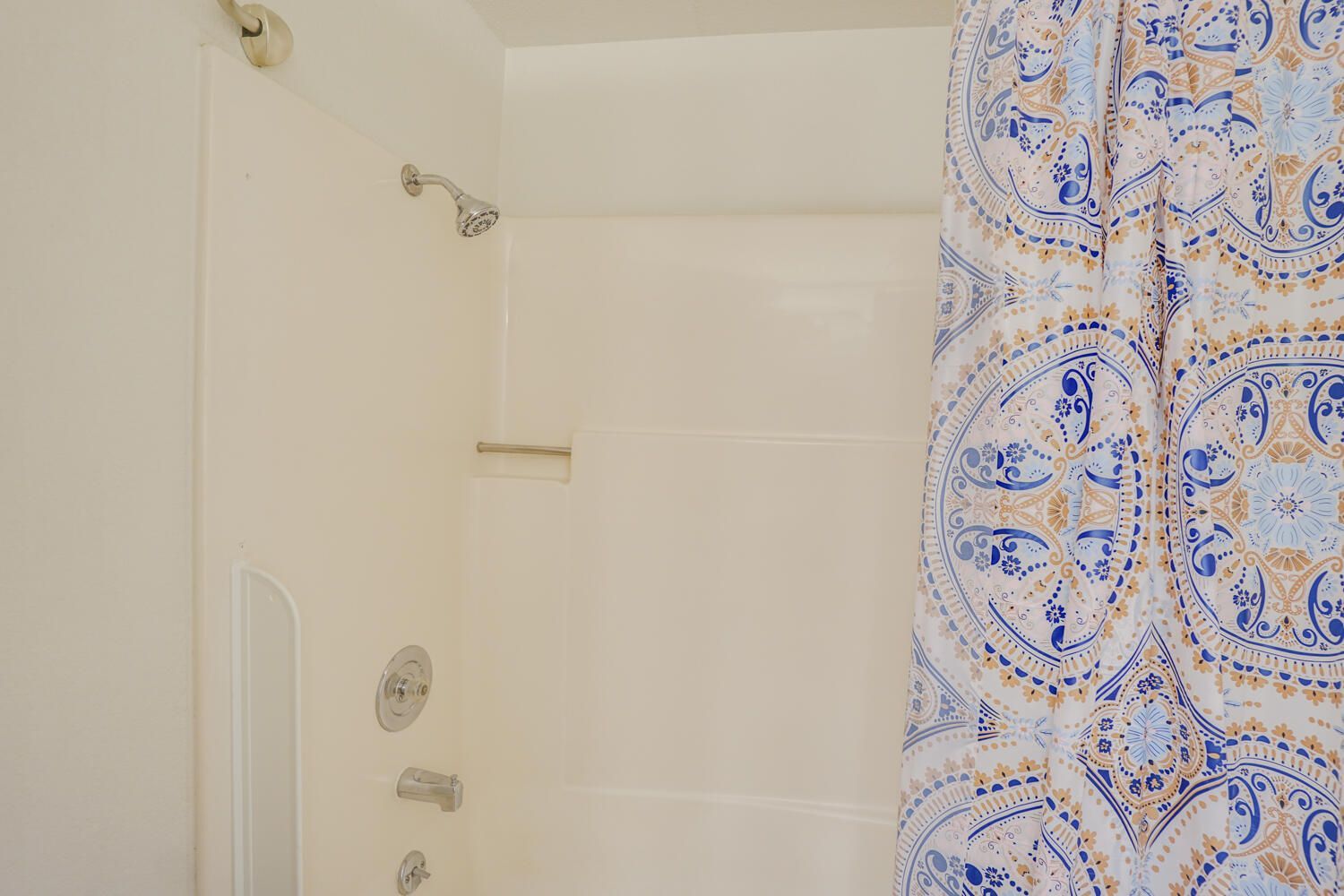A bathroom with a shower curtain and a bathtub.