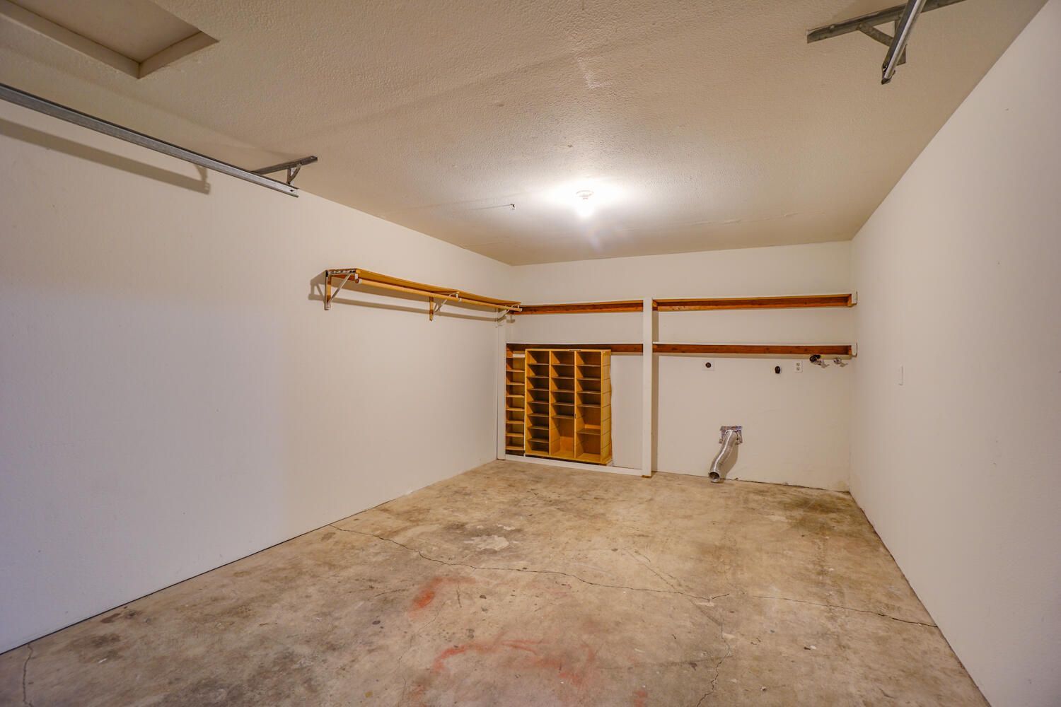 An empty garage with white walls and a concrete floor