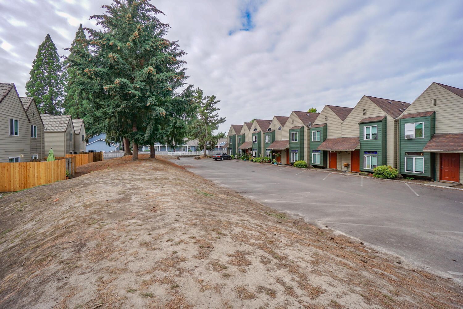 A row of apartment buildings with a lot of parking in front of them.