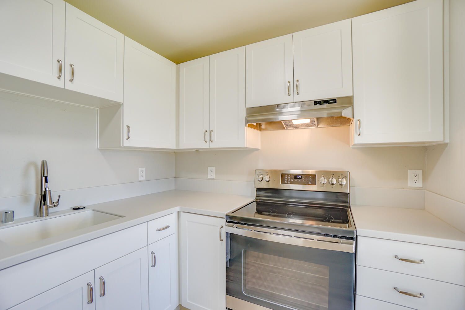 A kitchen with white cabinets and stainless steel appliances