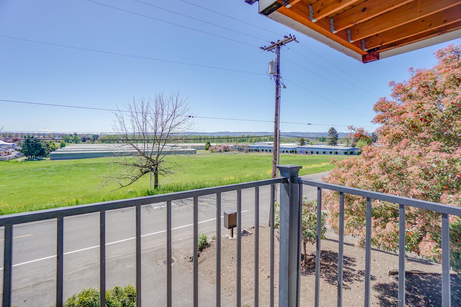 A balcony with a view of a field and a road.