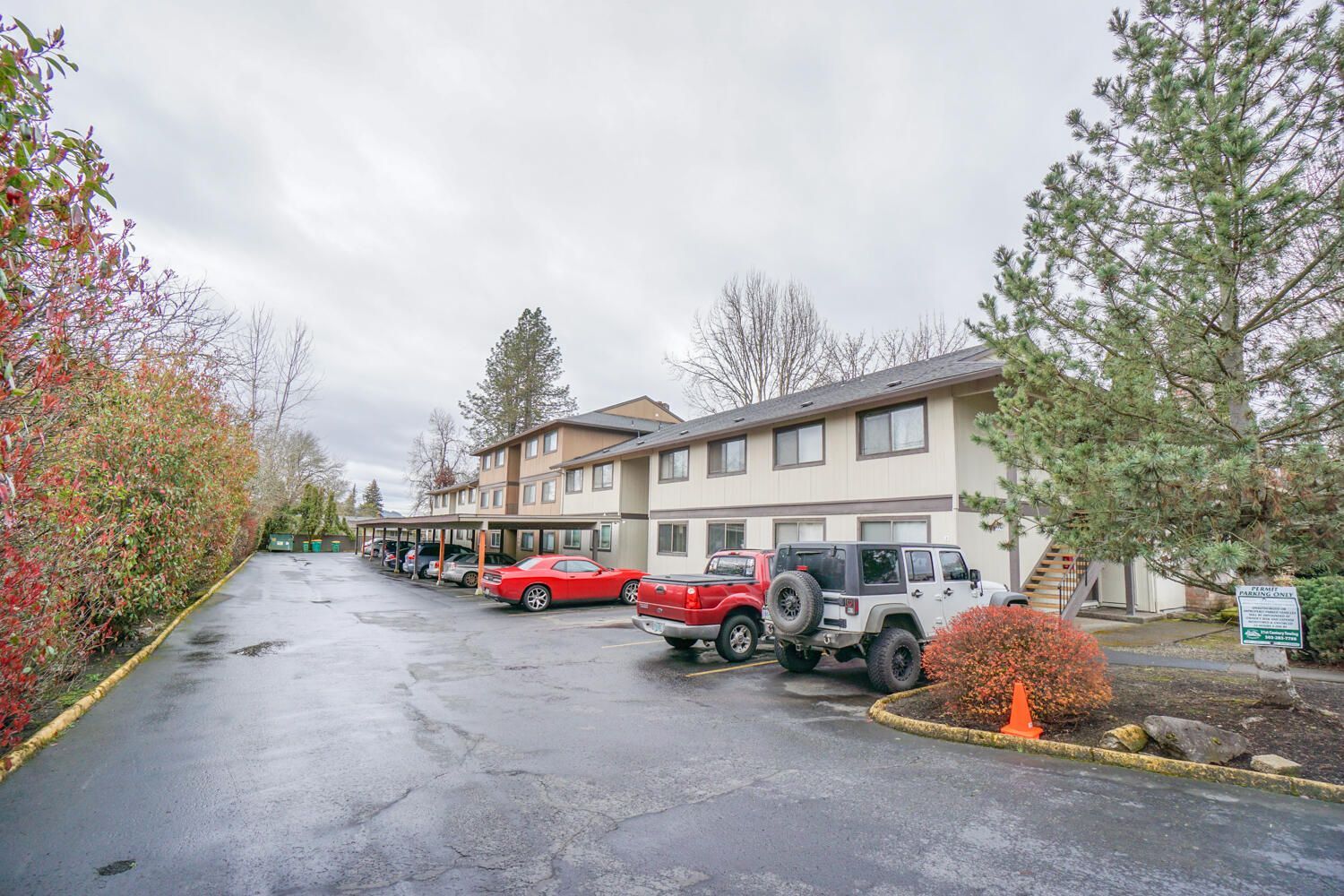 A parking lot with cars parked in front of a building.