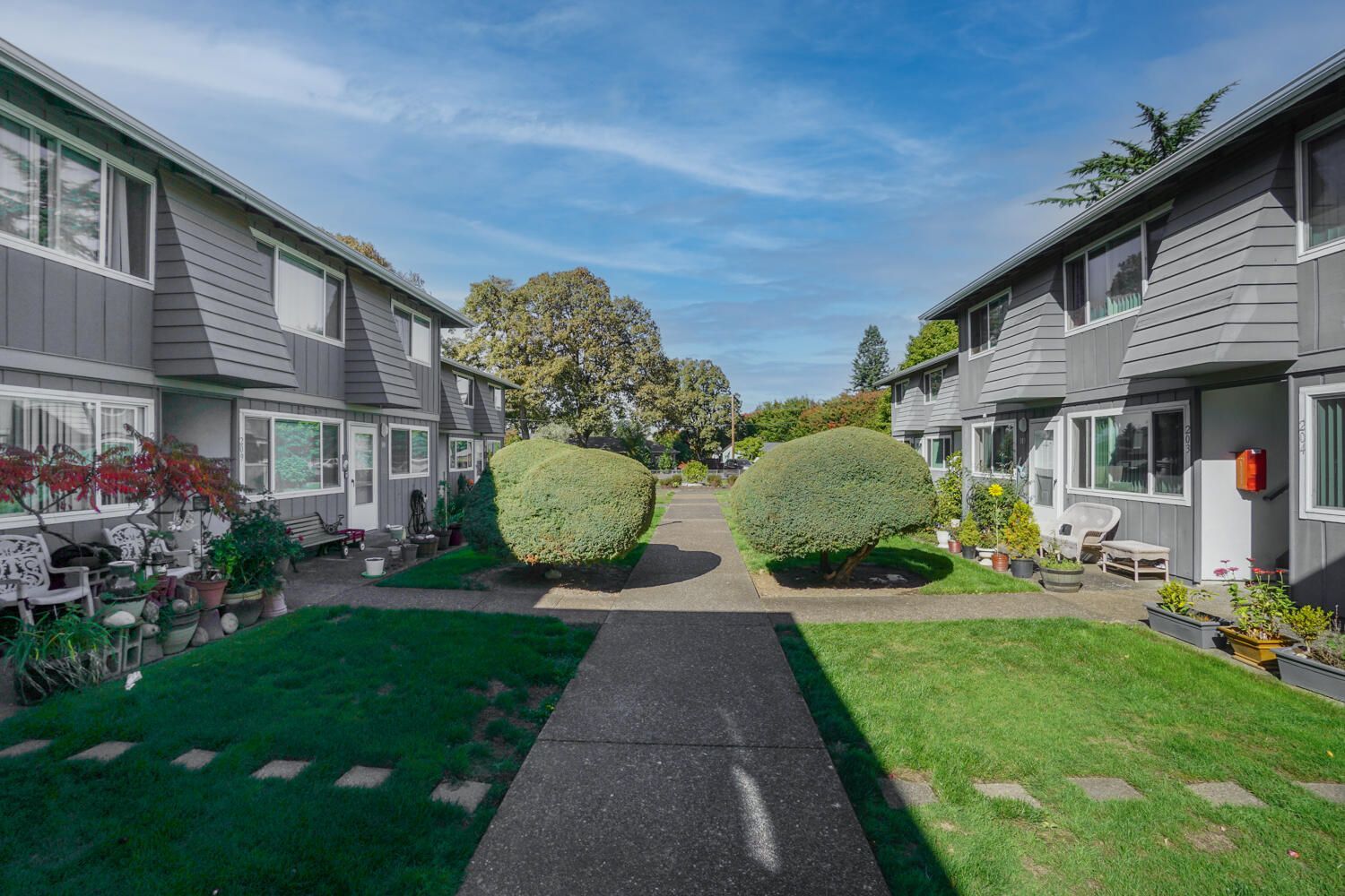 A row of apartment buildings with a walkway between them.