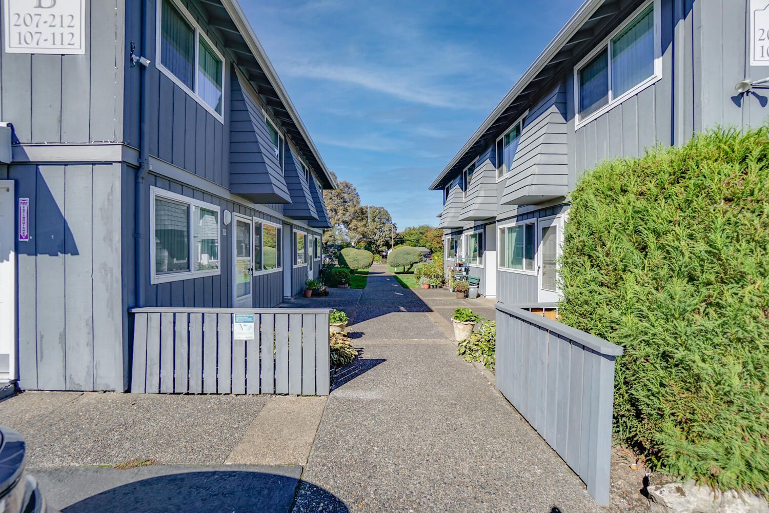 A row of apartment buildings with a walkway between them.