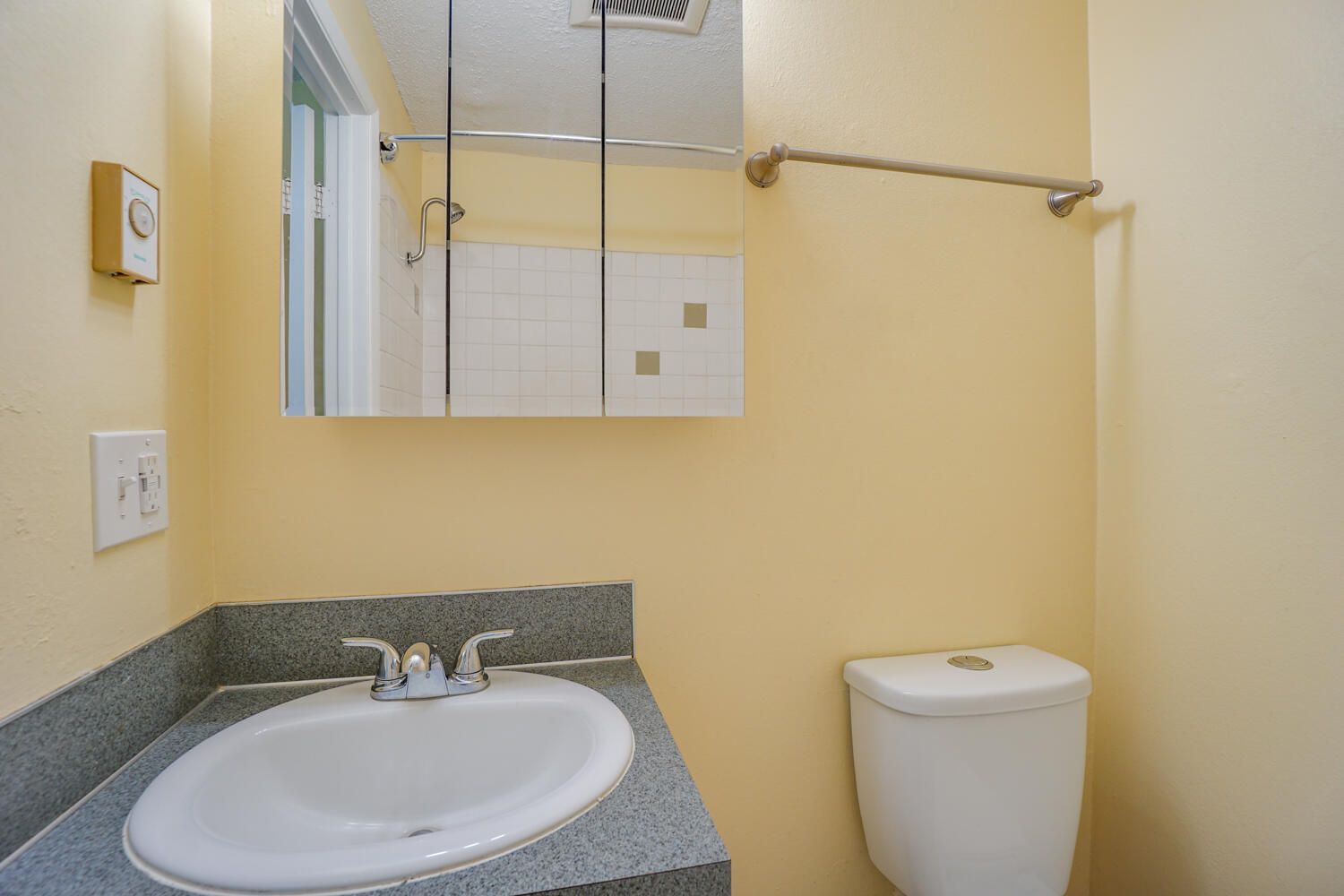 A bathroom with a sink , toilet and mirror.