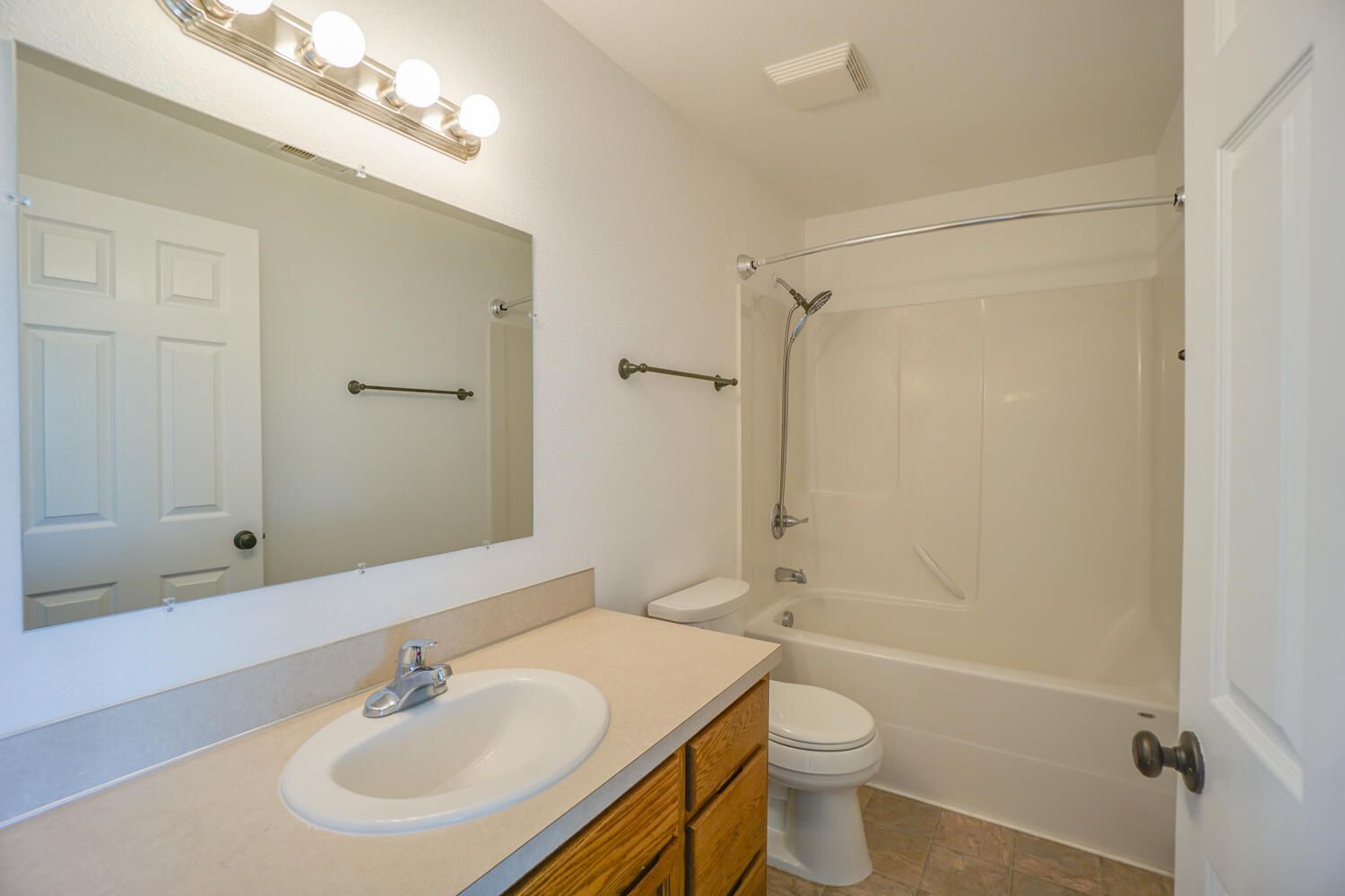 A bathroom with a sink , toilet , bathtub and mirror.