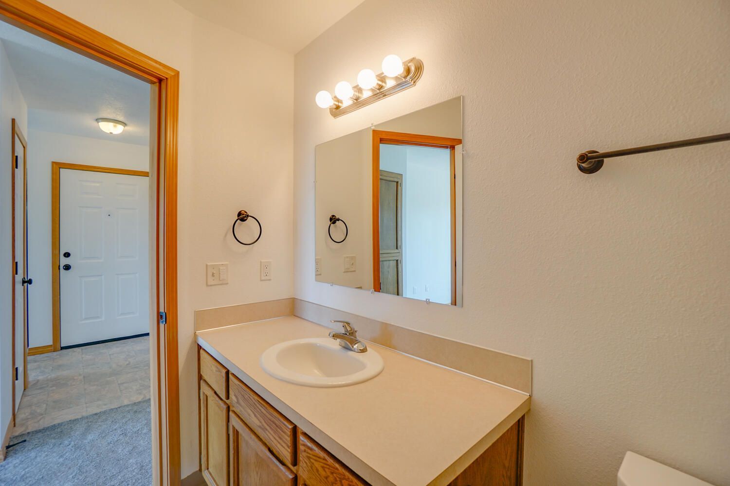 A bathroom with a sink , mirror and toilet.