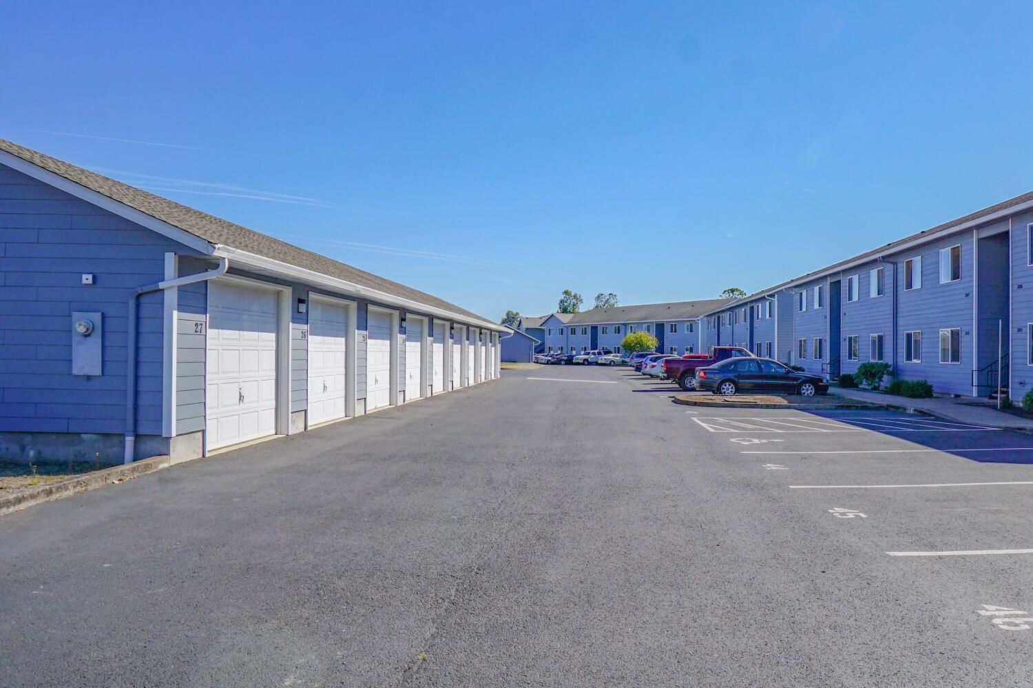 A parking lot with a lot of cars parked in front of a building.