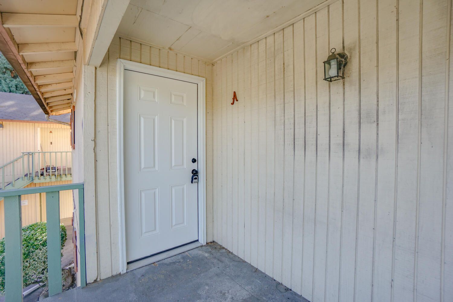 A white door is sitting on a porch of a house.