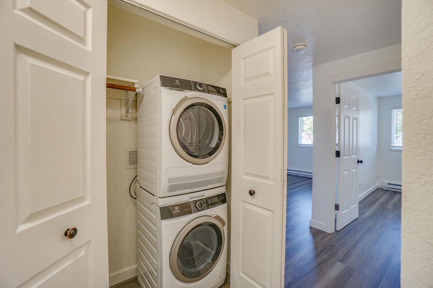 A washer and dryer are stacked on top of each other in a closet.