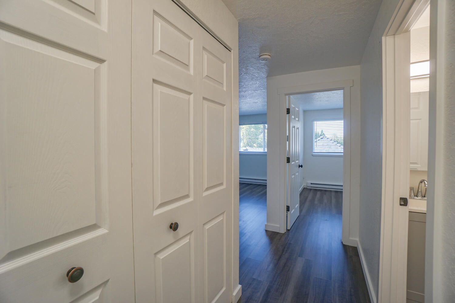 A hallway in a house with a closet and a bathroom.