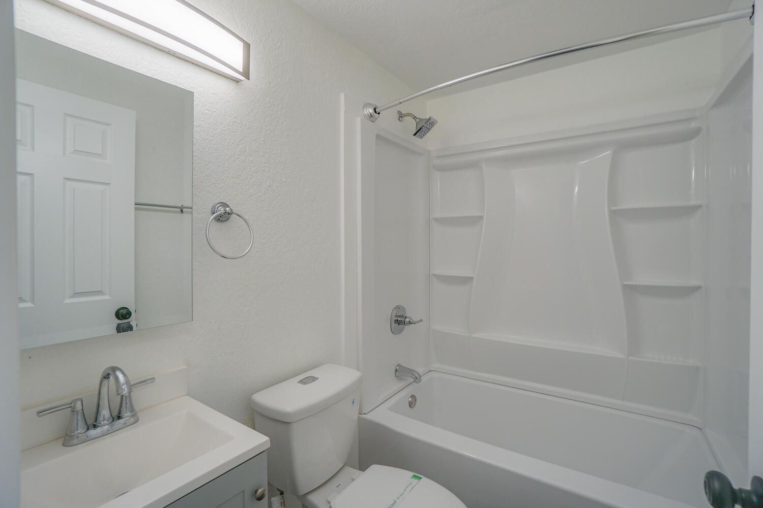 A bathroom with a toilet , sink and bathtub.