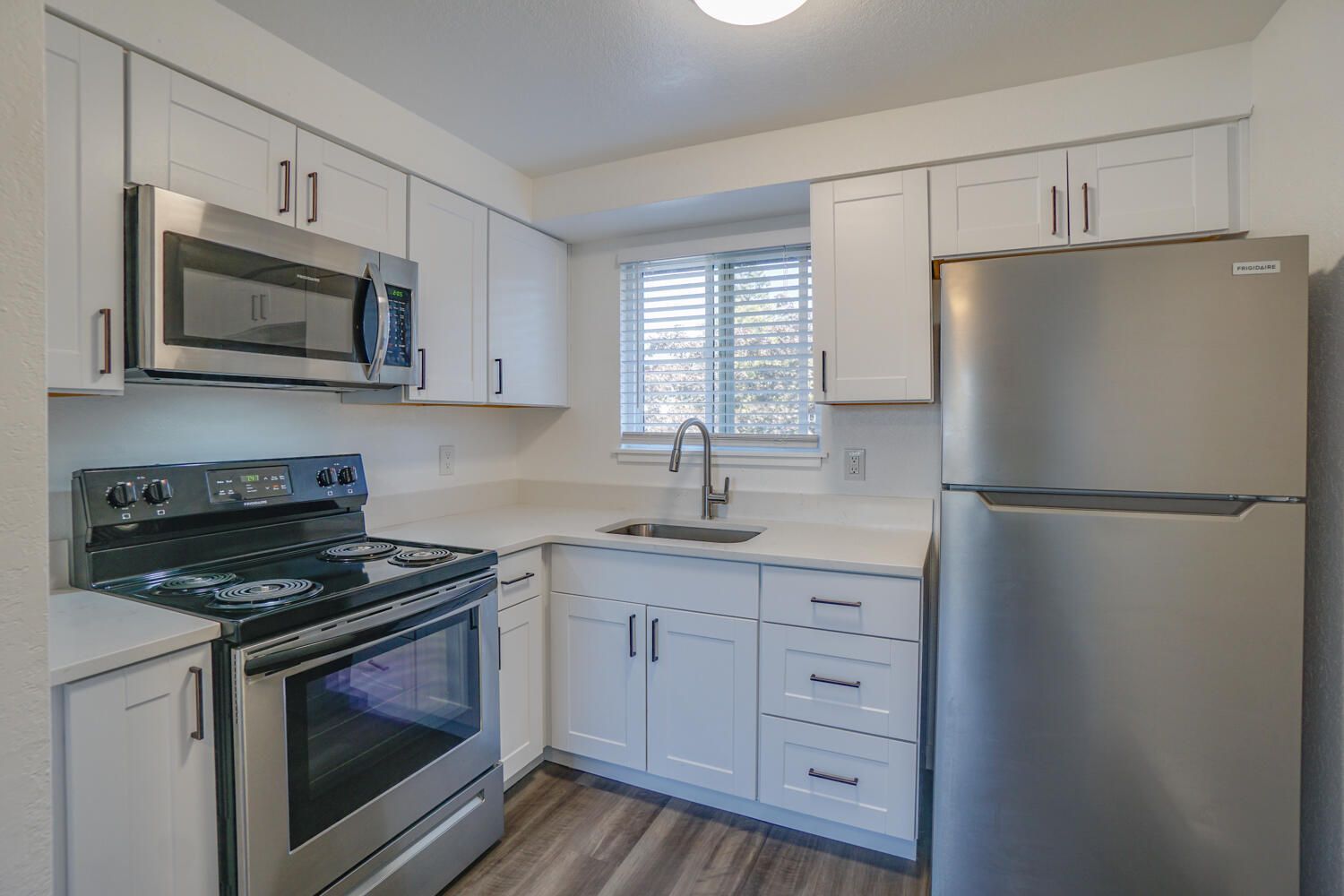 A kitchen with stainless steel appliances and white cabinets.