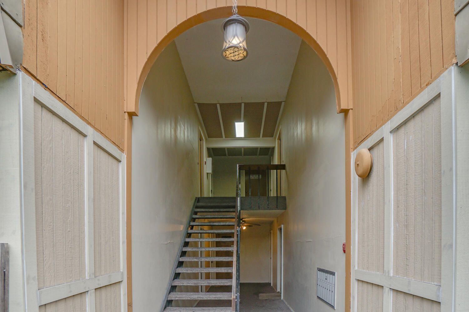 A hallway with stairs leading up to the second floor of a building.