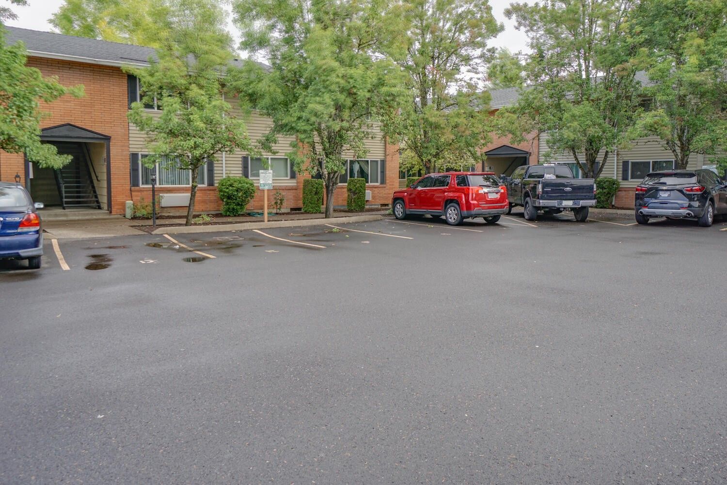 A parking lot with cars parked in front of a building.