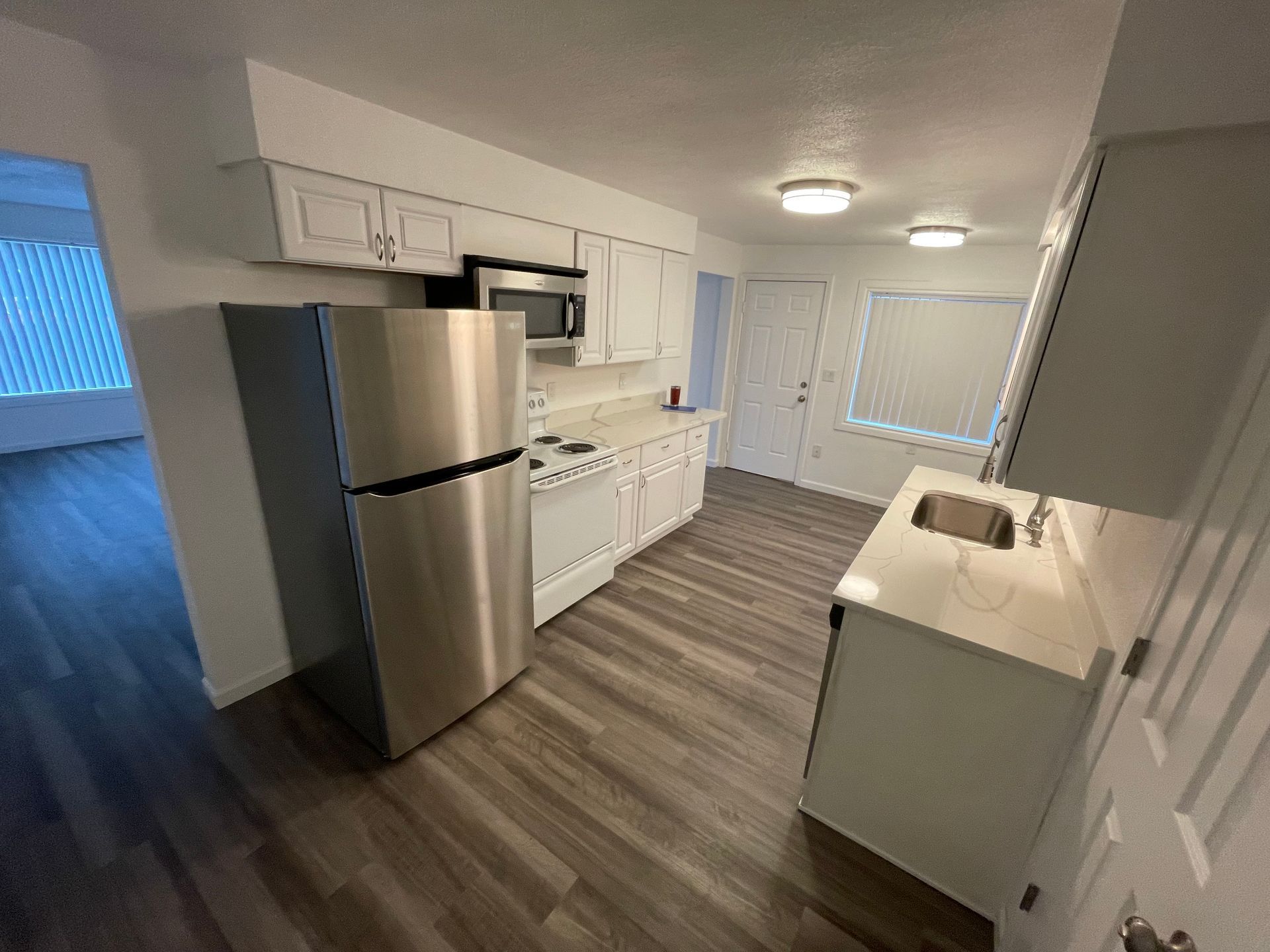 A kitchen with stainless steel appliances and white cabinets.