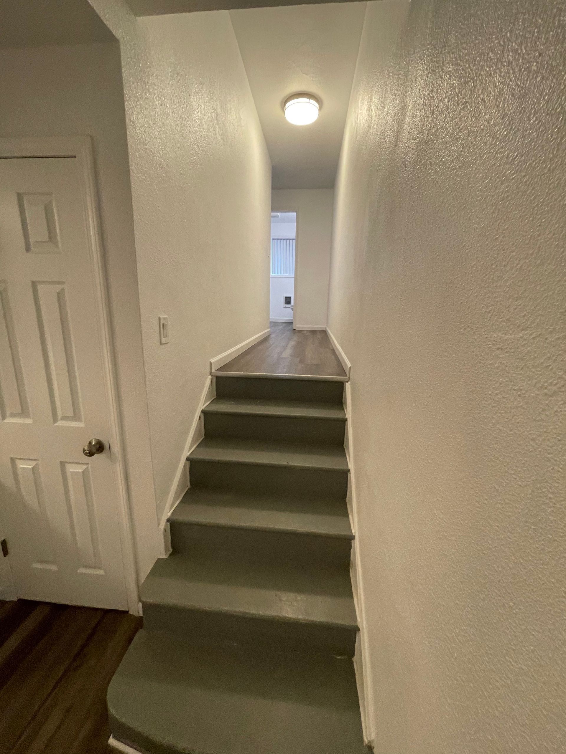 A hallway with stairs leading up to the second floor of a house.