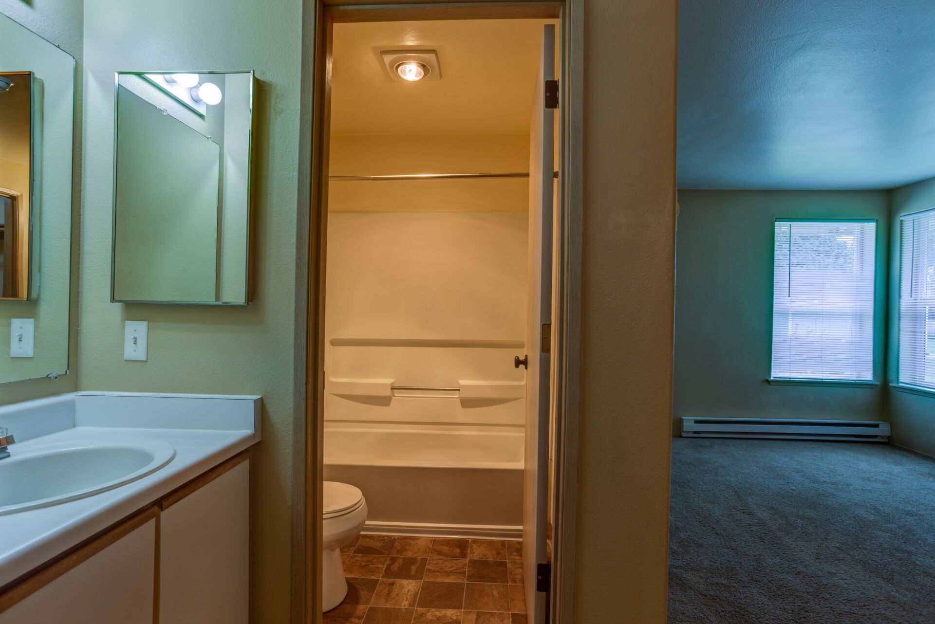 A bathroom with a sink , toilet , bathtub and mirror.