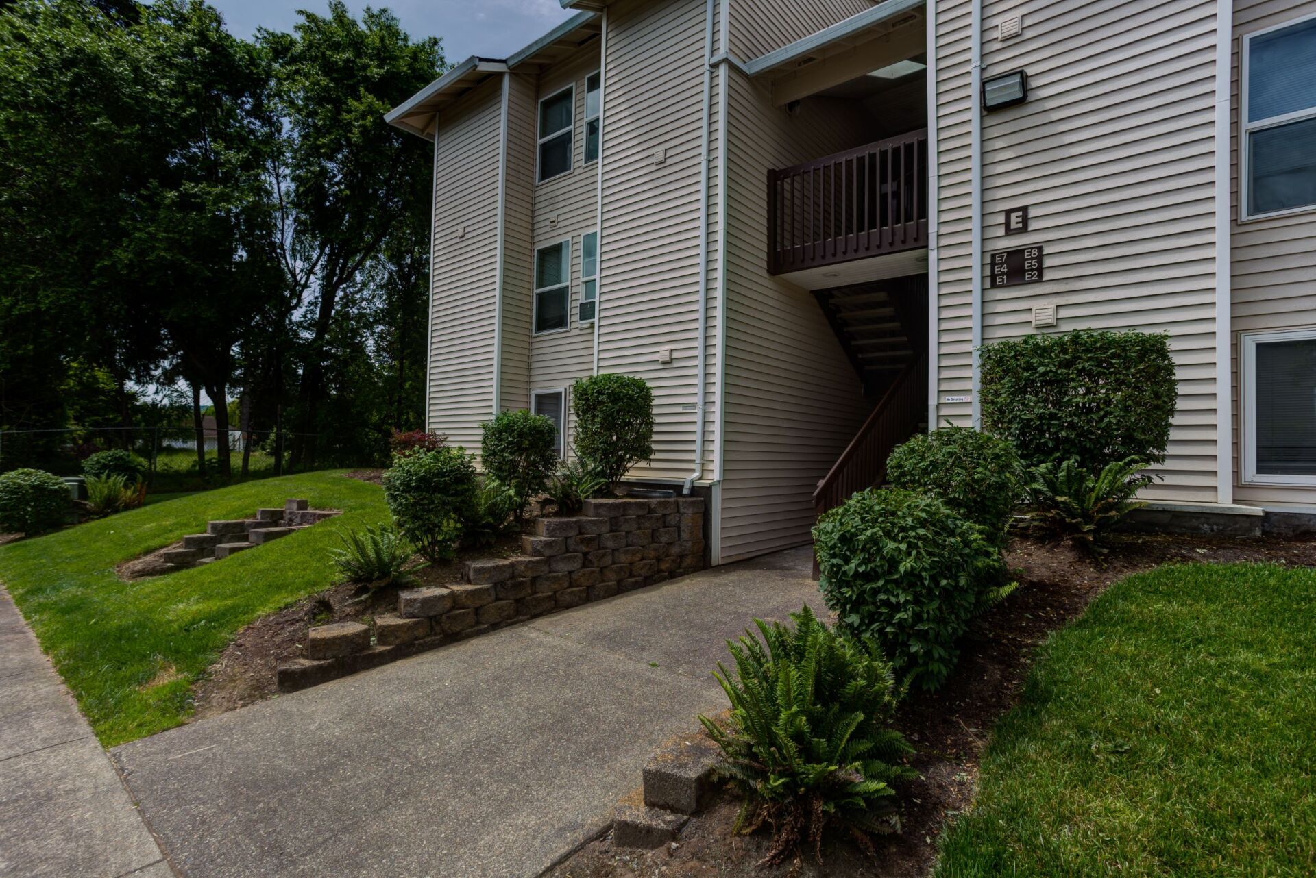 A large apartment building with stairs leading up to the second floor.