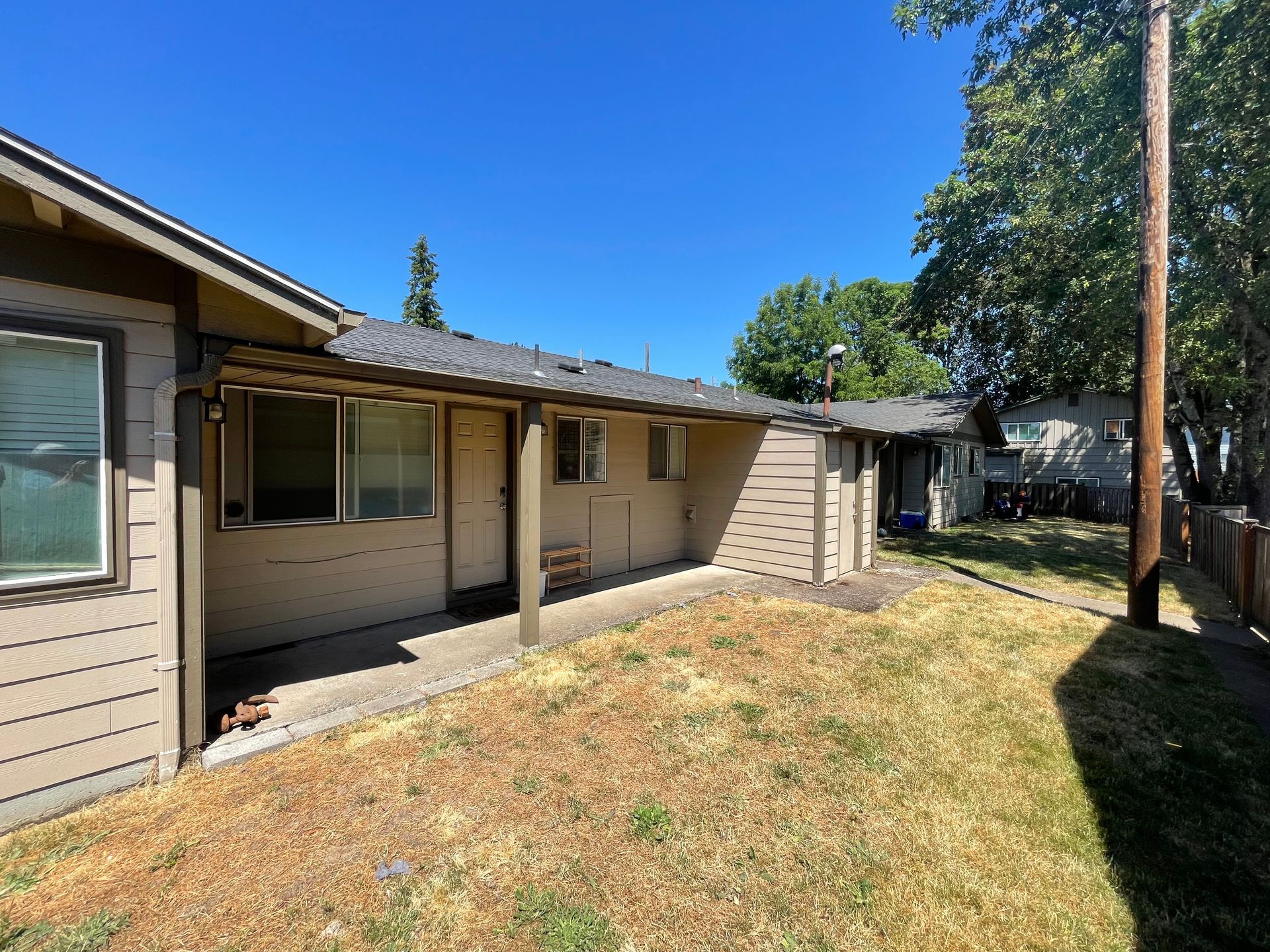A house with a covered porch and a fence in front of it.