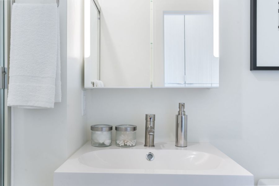 A bathroom with a sink , mirror and toilet.