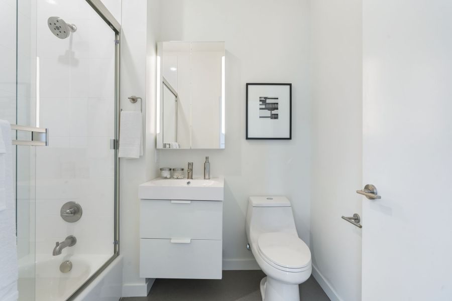 A bathroom with a toilet , sink and shower.