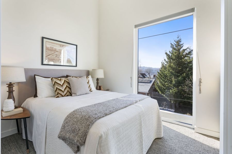 A bedroom with a large bed and a large window.