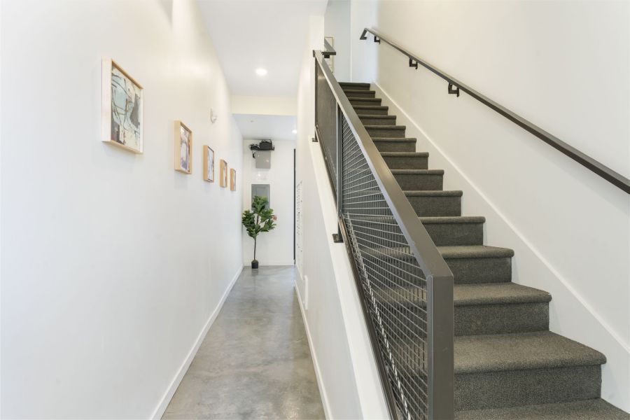 A hallway with stairs leading up to the second floor