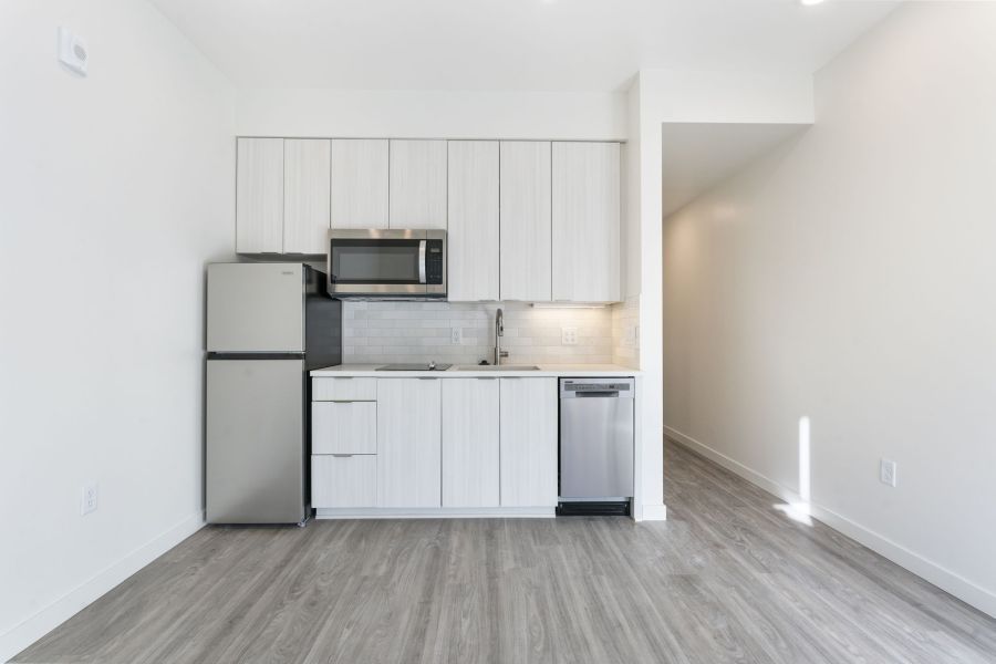 A kitchen with white cabinets and stainless steel appliances