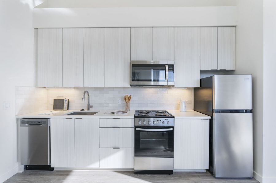 A kitchen with white cabinets and stainless steel appliances