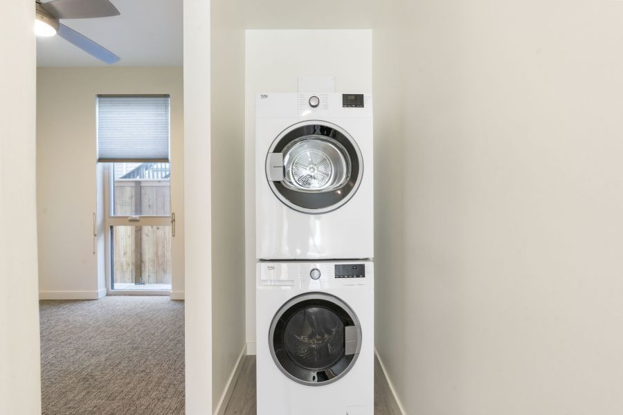 A washer and dryer are stacked on top of each other in a laundry room.