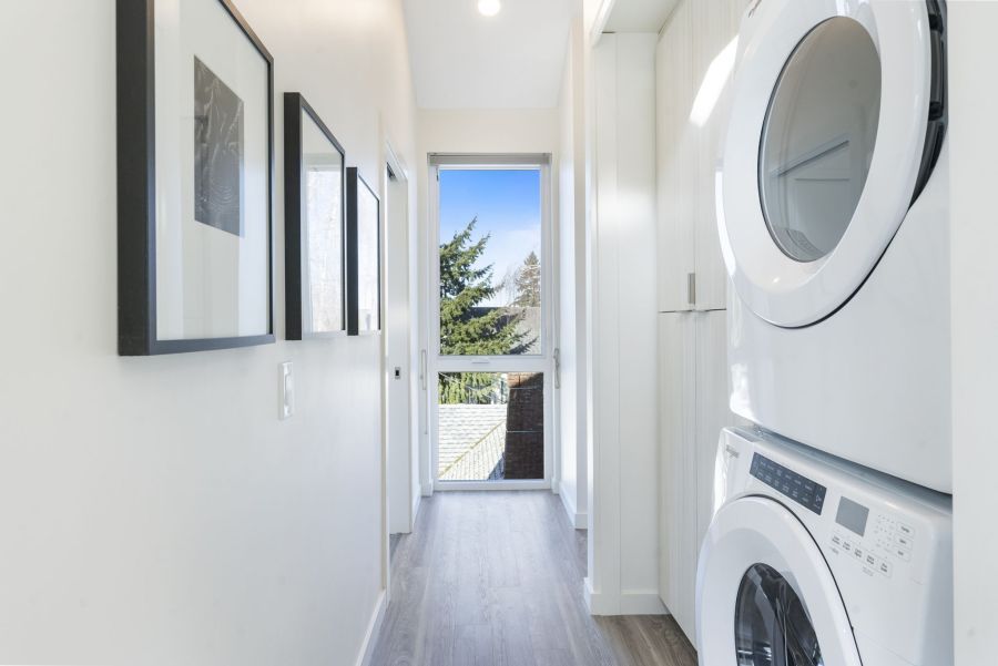 A hallway with a washer and dryer stacked on top of each other.