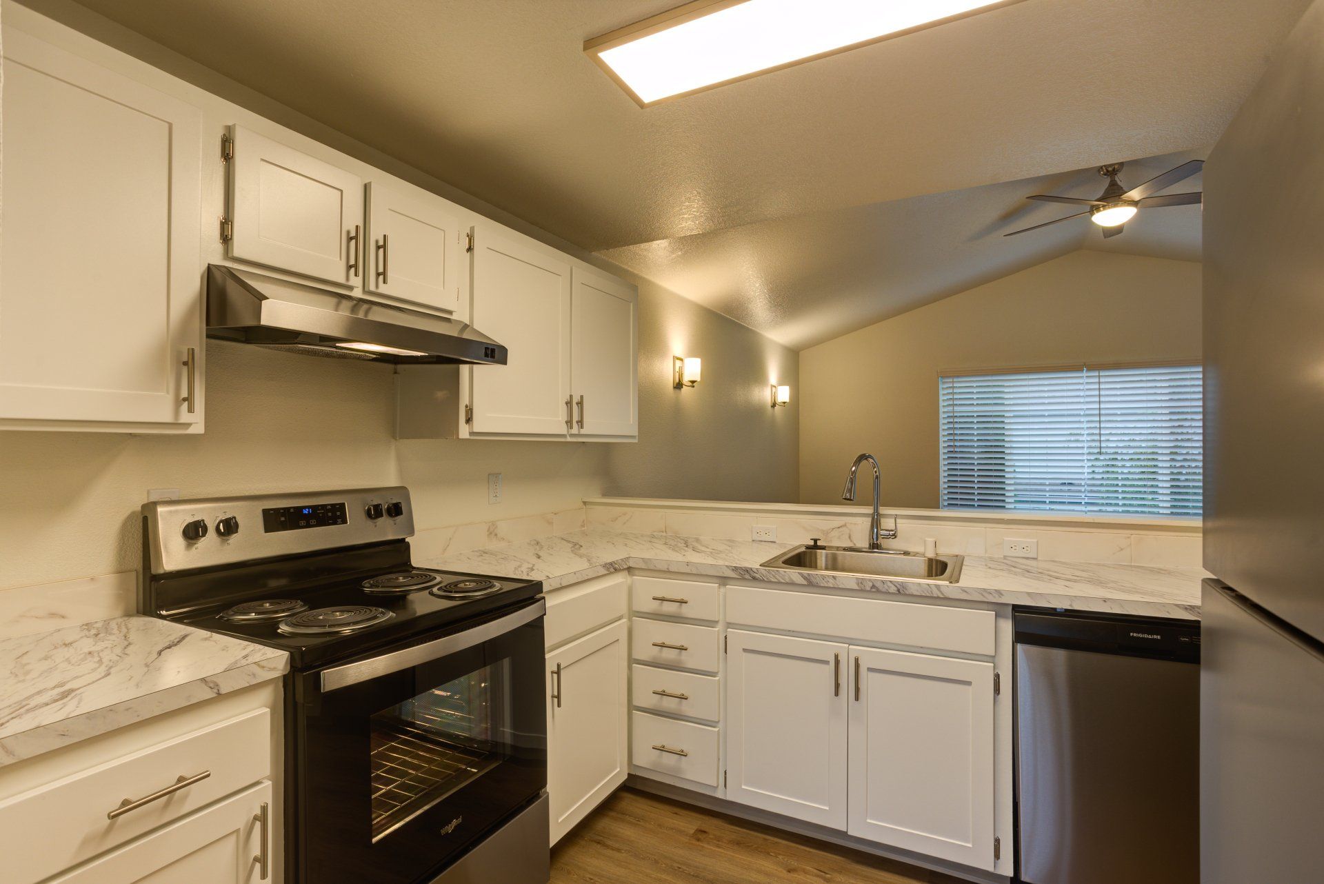 A kitchen with white cabinets and stainless steel appliances