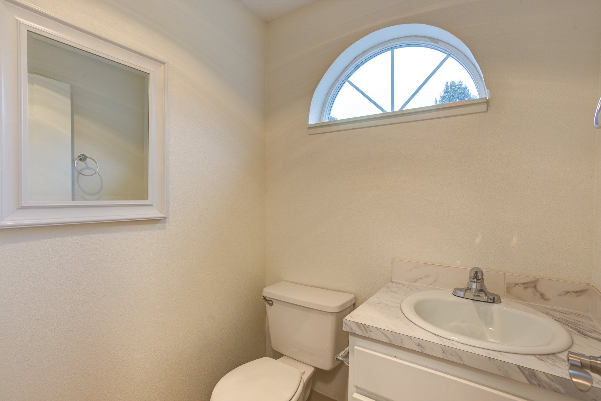 A bathroom with a toilet a sink and a mirror