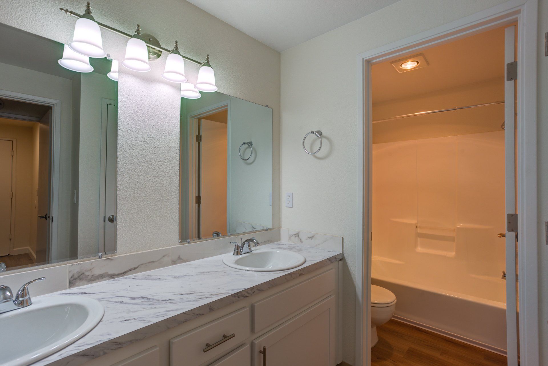 A bathroom with two sinks and a large mirror.