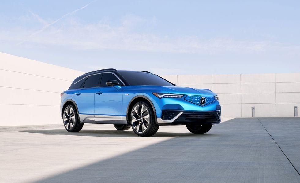 Blue SUV parked on a rooftop with a white wall and pale sky in the background