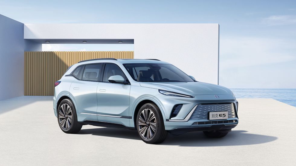 Light blue SUV parked outside a modern white seaside house