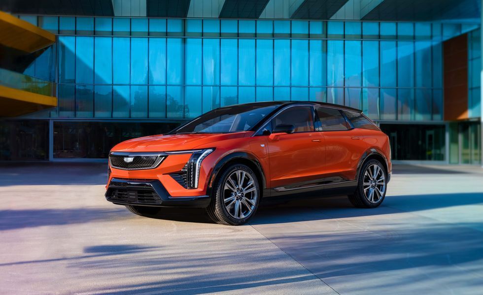 Orange SUV parked in front of a modern glass building